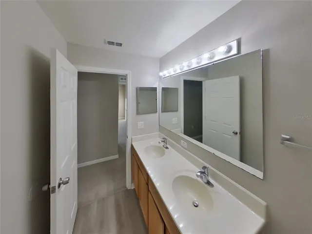a bathroom with a double vanity sink and a mirror