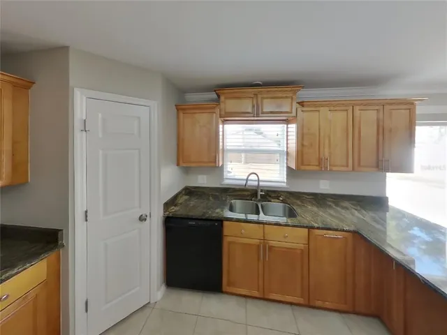 a kitchen with granite countertop a sink stove and cabinets