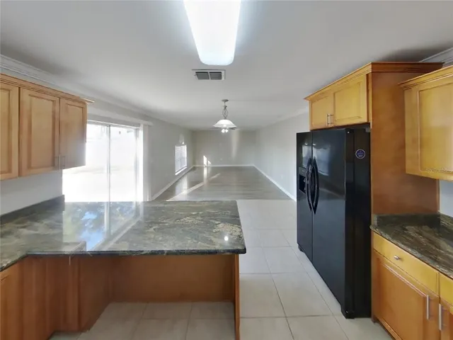 a kitchen with stainless steel appliances granite countertop a refrigerator a sink and a stove