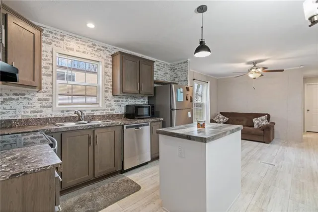 a kitchen with stainless steel appliances granite countertop a sink stove and refrigerator