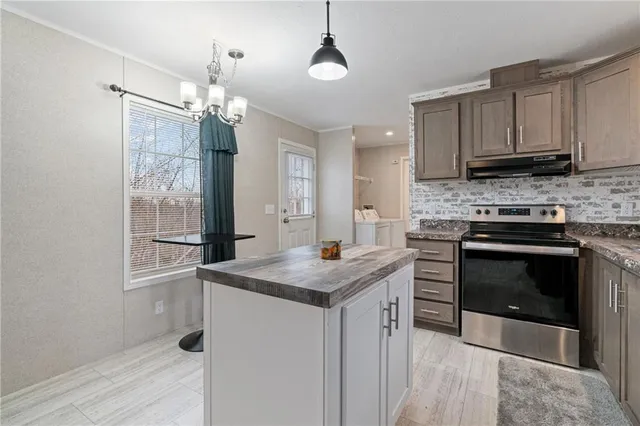 a kitchen with stainless steel appliances granite countertop a stove and a sink