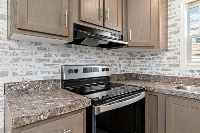 a kitchen with stainless steel appliances a refrigerator and a stove top oven