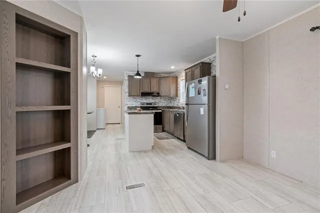 a kitchen with stainless steel appliances granite countertop a refrigerator and a stove top oven