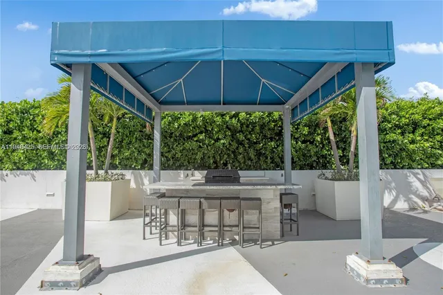a view of a patio with table and chairs under an umbrella