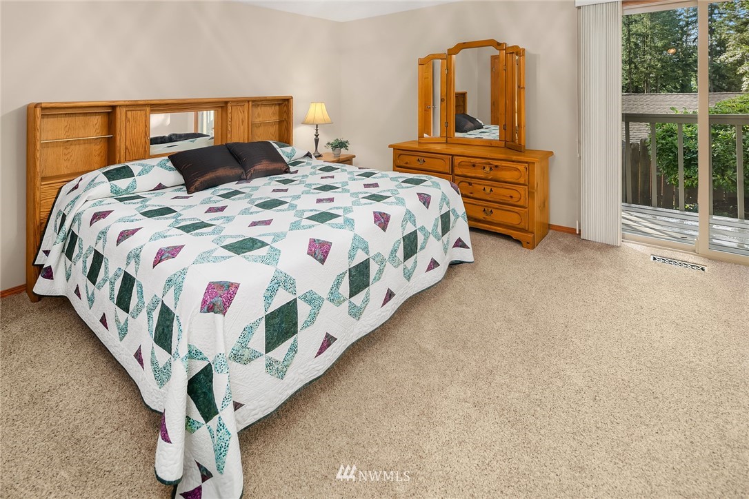 16433 Southeast 149th Street Renton, WA 98059 - Photo 18 of 22 a bedroom with a bed lamp and a large window