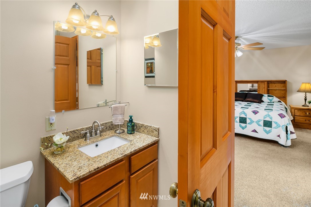 16433 Southeast 149th Street Renton, WA 98059 - Photo 20 of 22 a en suite bathroom with a granite countertop sink and a mirror