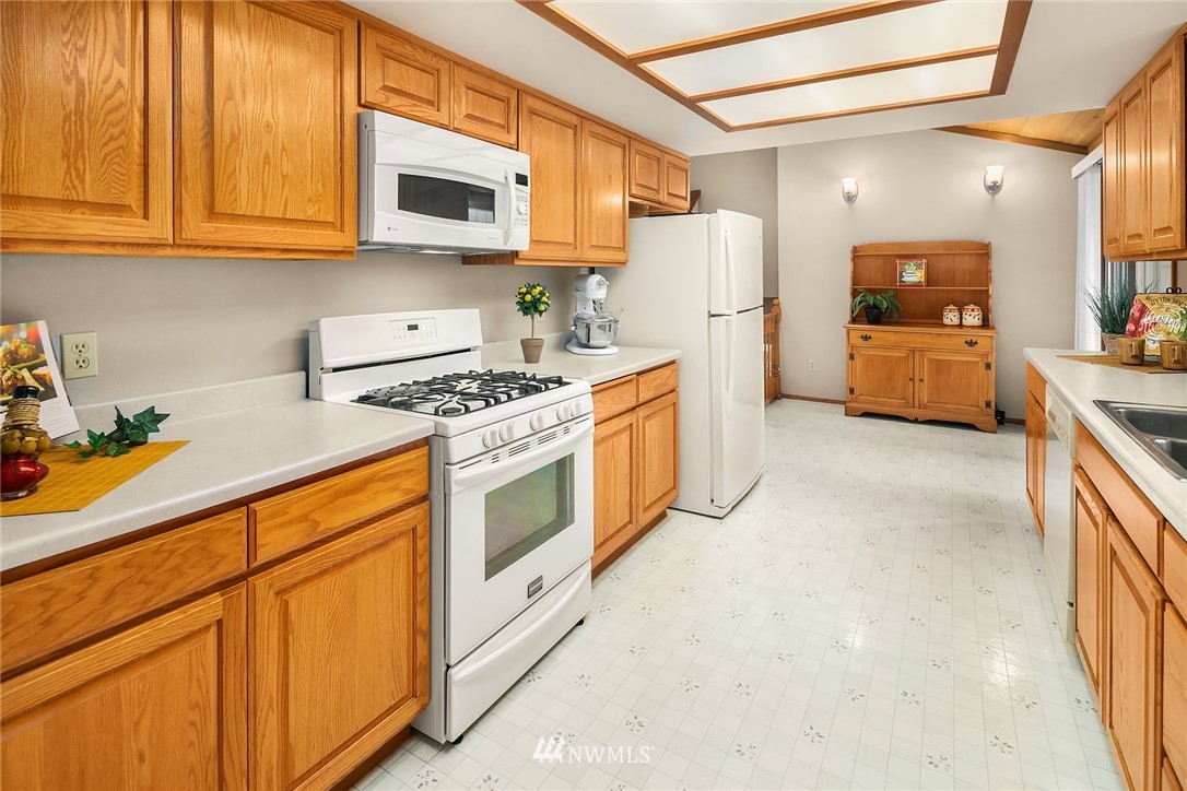 16433 Southeast 149th Street Renton, WA 98059 - Photo 7 of 22 a kitchen with stainless steel appliances white cabinets and a stove top oven