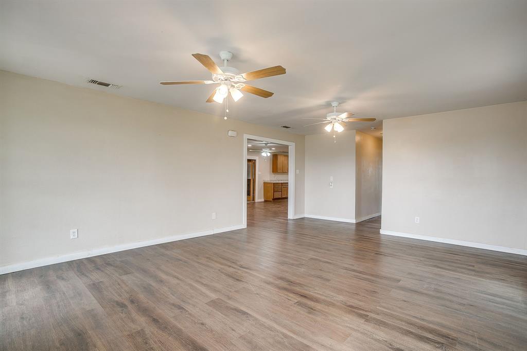 6260 Silver Creek Azle Road Azle, TX 76020 - Photo 15 of 40 a view of an empty room with wooden floor and a ceiling fan