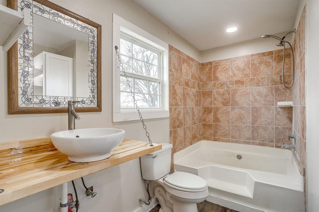6260 Silver Creek Azle Road Azle, TX 76020 - Photo 18 of 40 a bathroom with a sink a toilet a mirror a bathtub and shower