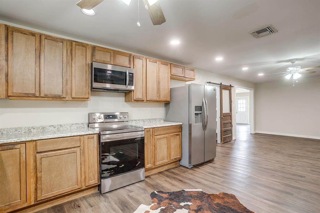6260 Silver Creek Azle Road Azle, TX 76020 - Photo 8 of 40 a kitchen with stainless steel appliances granite countertop a refrigerator stove microwave and sink