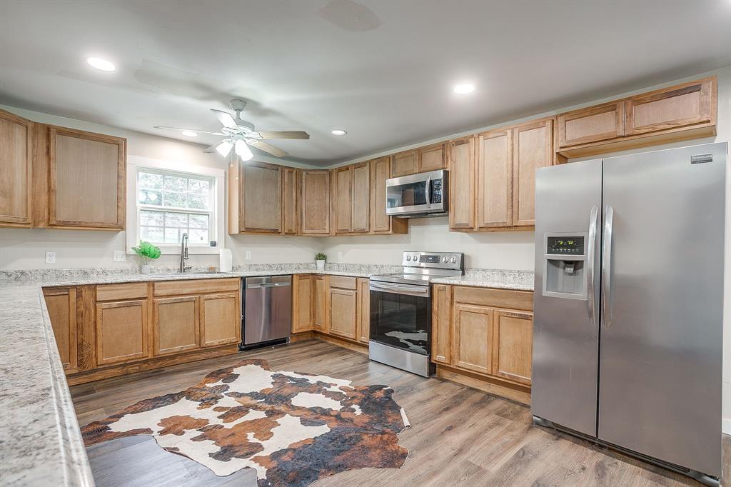 6260 Silver Creek Azle Road Azle, TX 76020 - Photo 9 of 40 a kitchen with granite countertop a refrigerator stove top oven and sink