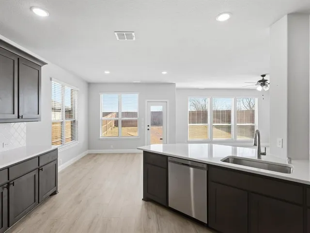 a large kitchen with granite countertop a large window and a sink