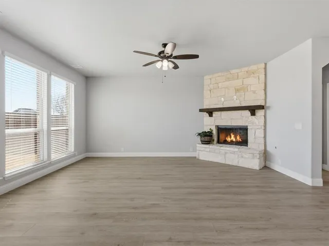 an empty room with windows and fireplace
