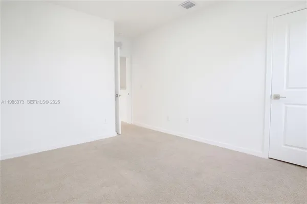 a view of a house with a yard and lawn chairs with plants and palm trees