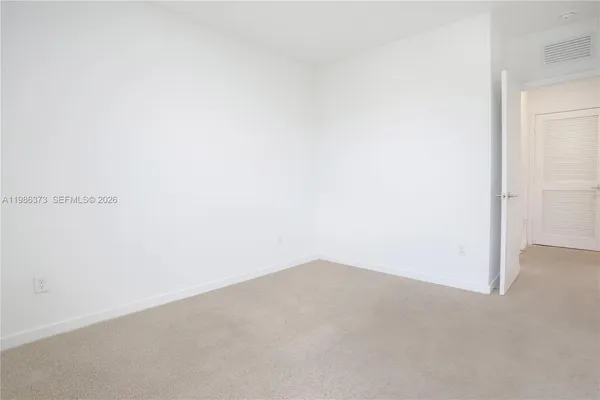 a kitchen with stainless steel appliances granite countertop a stove top oven a sink a refrigerator white cabinets and wooden floor