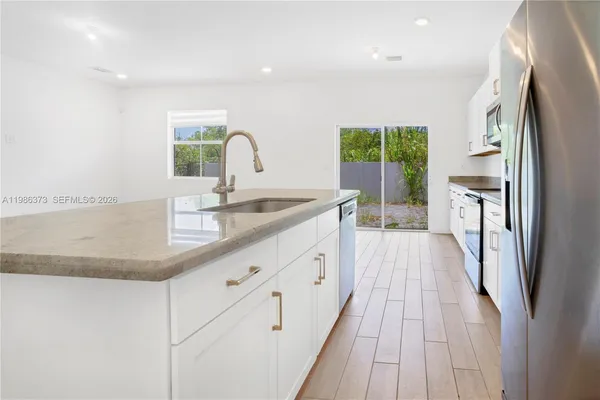 a view of kitchen with stainless steel appliances refrigerator oven and cabinets