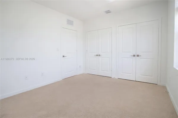 a kitchen with stainless steel appliances granite countertop a stove top oven a sink a refrigerator and white cabinets