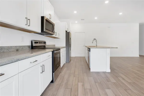 a view of a house with a yard and palm trees