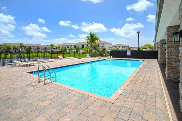 a view of a house with swimming pool and sitting area