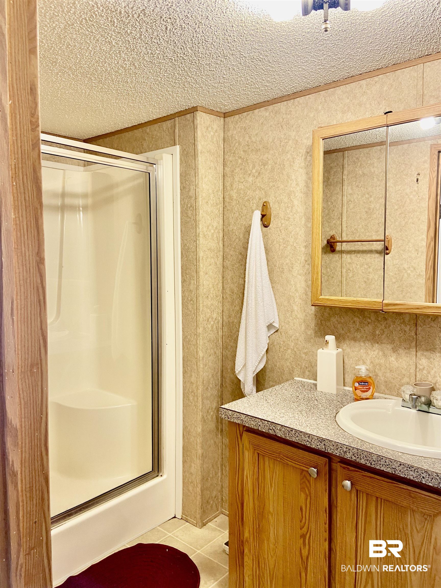 294 Eureka Way Uriah, AL 36480 - Photo 13 of 18 Bathroom with a textured ceiling, a shower stall, vanity, and tile patterned floors