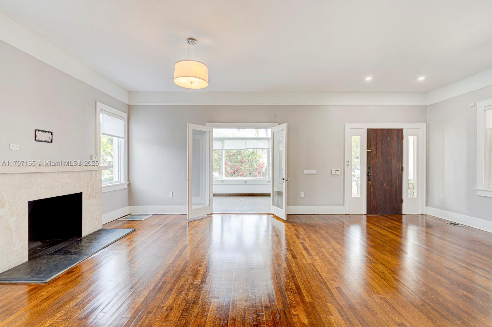 428 Southwest 23rd Road Miami, FL 33129 - Photo 3 of 36 a view of an empty room with wooden floor and a window
