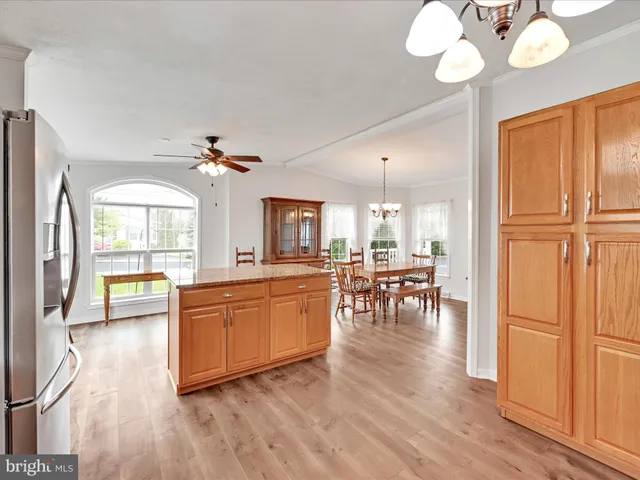 a large living room with stainless steel appliances granite countertop furniture a fireplace and wooden floor