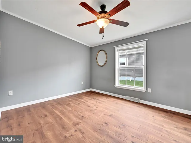 an empty room with windows and fan