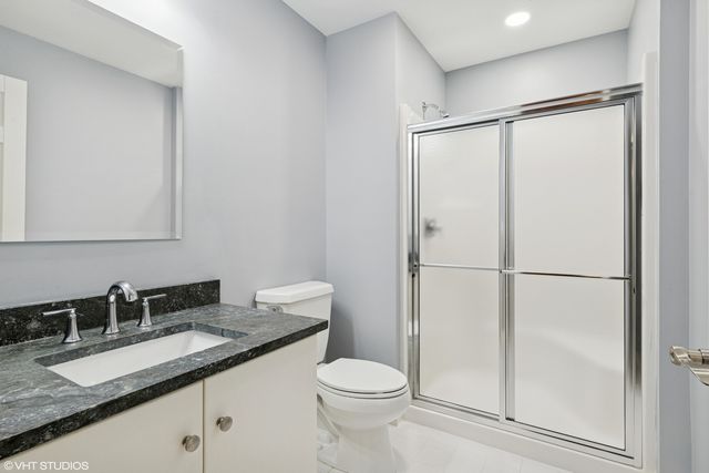 a bathroom with a granite countertop sink toilet and shower