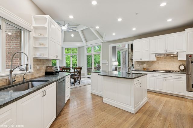 a kitchen with stainless steel appliances granite countertop wooden cabinets and sink