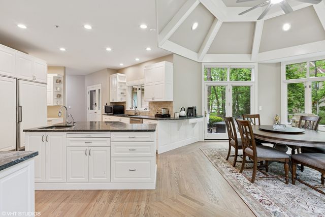 a kitchen with granite countertop white cabinets and chairs