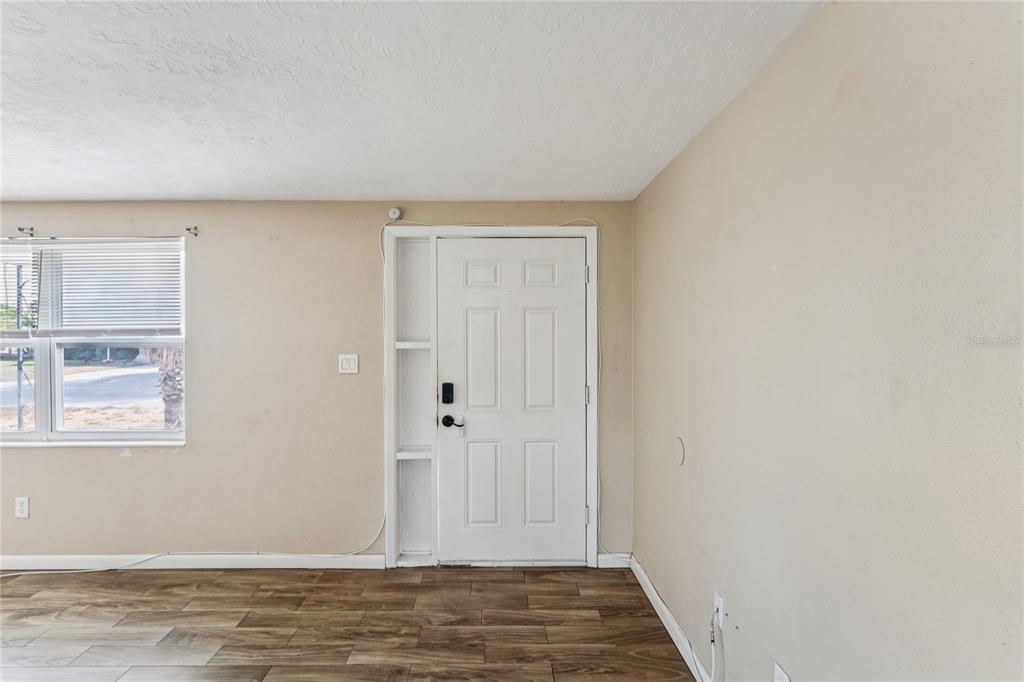 4837 Vision Avenue Holiday, FL 34690 - Photo 10 of 38 a view of an empty room with window and wooden floor
