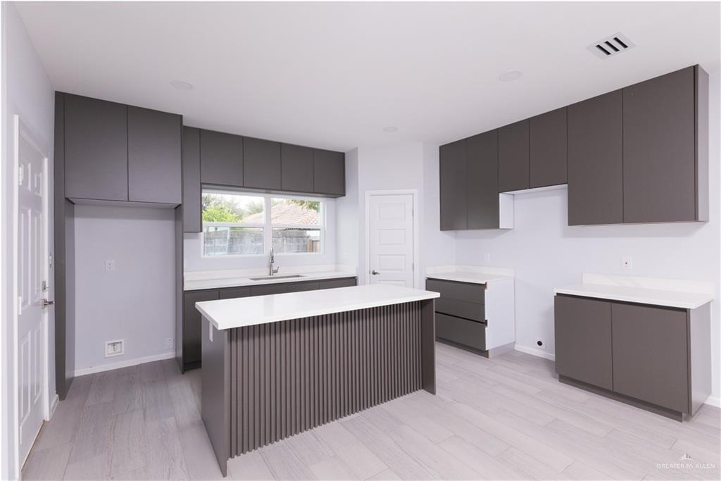 a kitchen with granite countertop a sink and cabinets