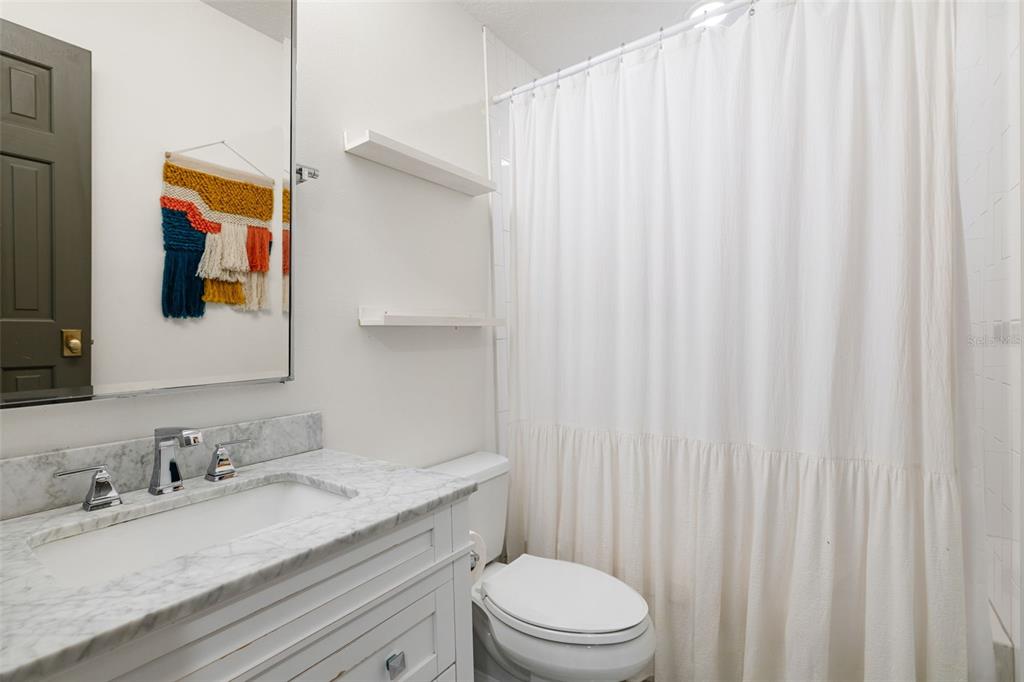 9116 Roberts Road Odessa, FL 33556 - Photo 51 of 94 a bathroom with a granite countertop sink vanity mirror and toilet