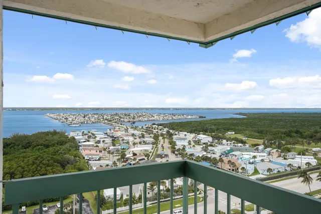 a bedroom with a bed and large window with balcony view