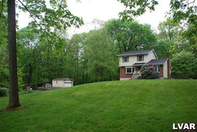 495 Buttermilk Road Hellertown, PA 18055 - Photo 3 of 34 a front view of a house with a garden and trees