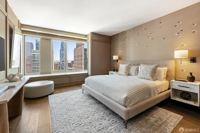 a bedroom with a bed couch and large window