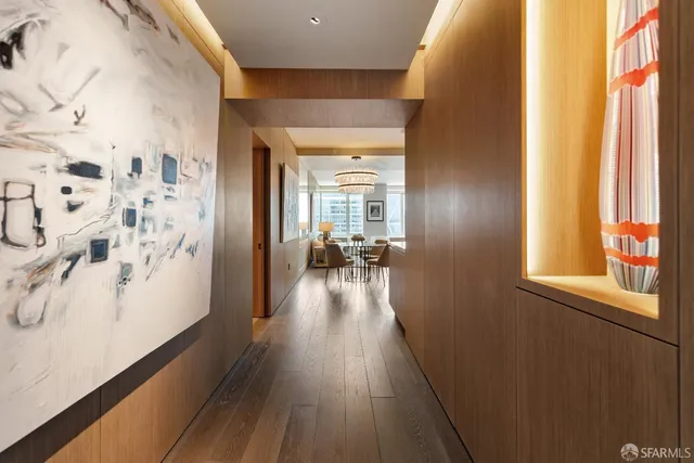 a view of a hallway with wooden floor and furniture