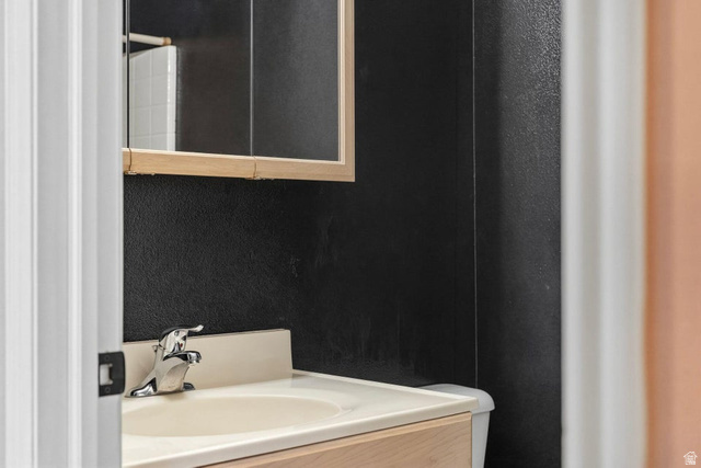 132 Rex Layne Drive Central, UT 84722 - Photo 22 of 39 Vanity with integrated sink and chrome faucet, set against a dark textured wall
