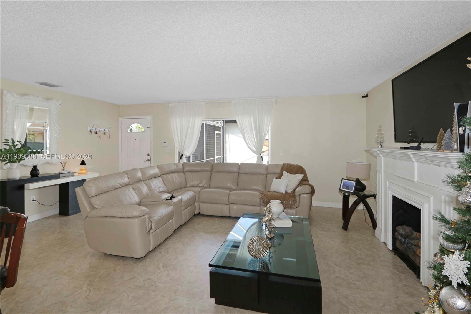 3825 Southwest 125th Avenue Miami, FL 33175 - Photo 4 of 13 a living room with furniture a flat screen tv and a fireplace