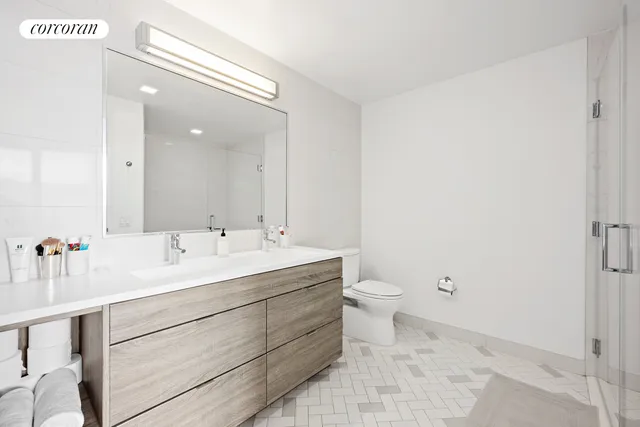 a bathroom with a double vanity sink toilet and a mirror