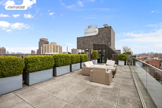 a view of roof deck with couches and wooden floor