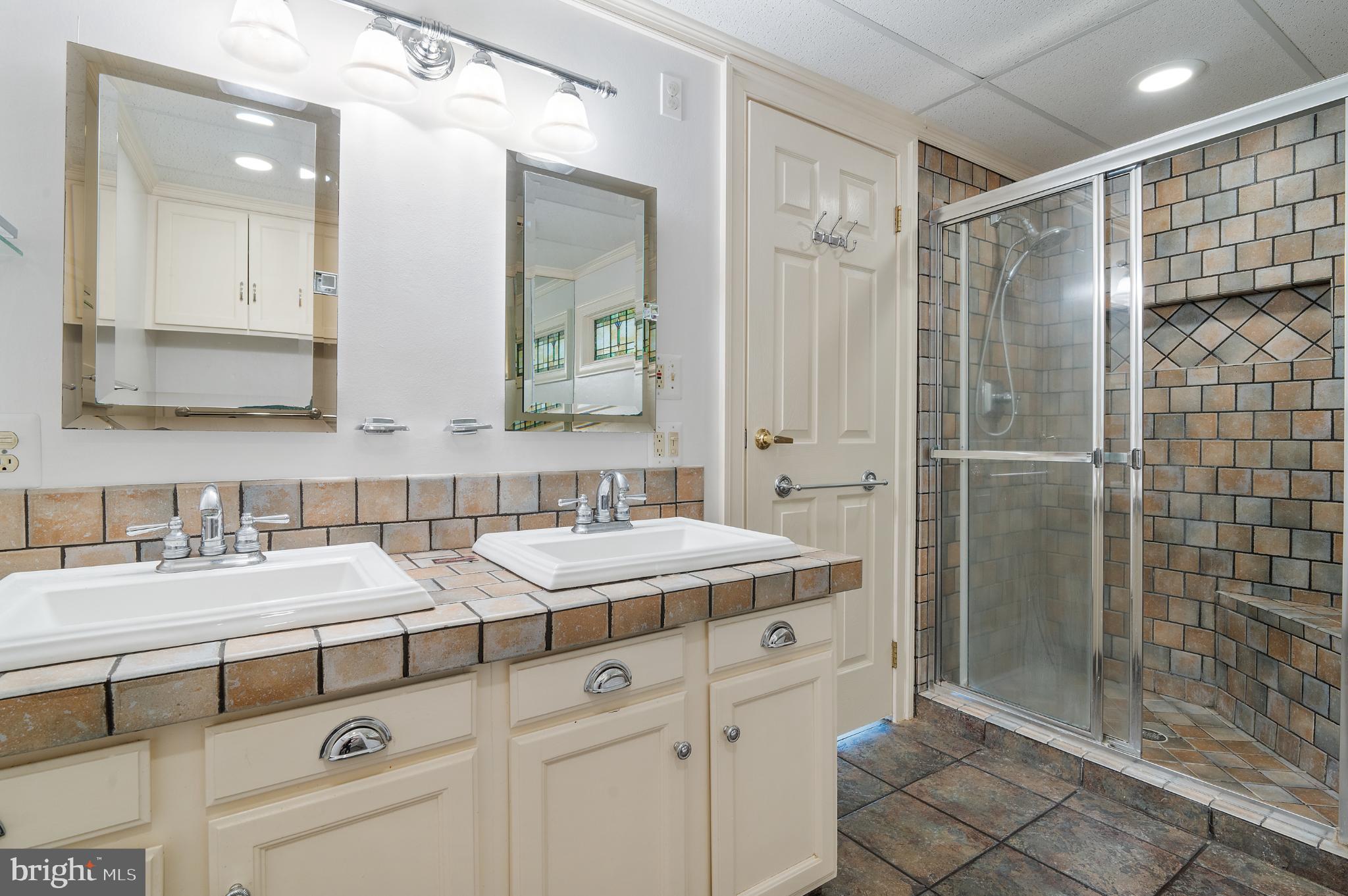 15729 Holly Grove Road Silver Spring, MD 20905 - Photo 53 of 83 primary dual-sink bathroom with tiled accents.