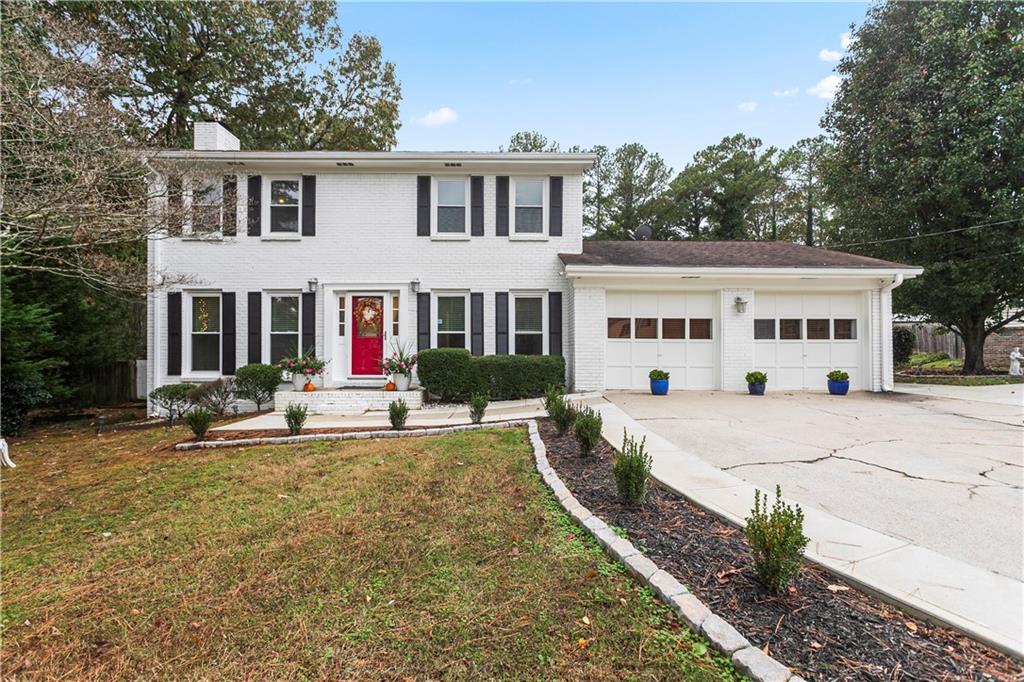 a view of a white house with open pool and sitting area