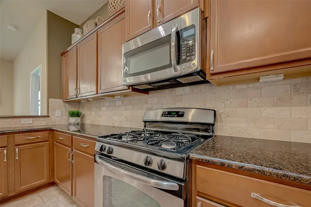 a kitchen with stainless steel appliances granite countertop a stove and a microwave