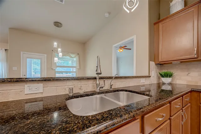 a bathroom with a granite countertop sink and a mirror