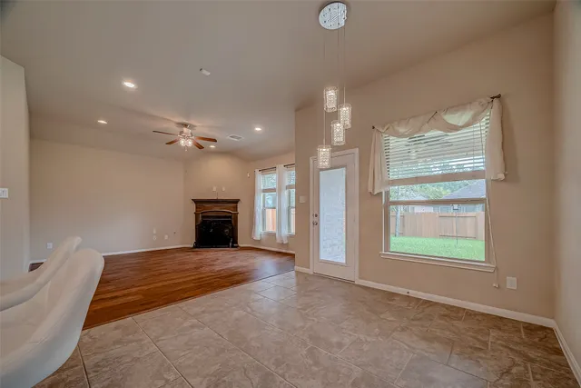 a view of an empty room with a fireplace and a window