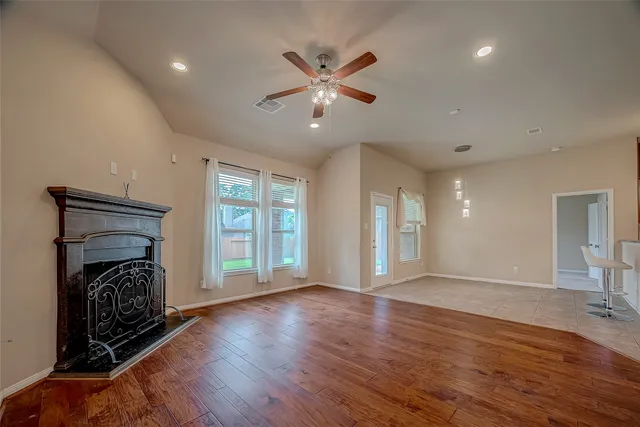 a view of an empty room with a window and wooden floor