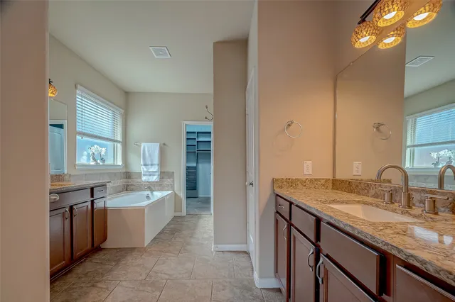 a bathroom with a granite countertop sink double vanity and a mirror