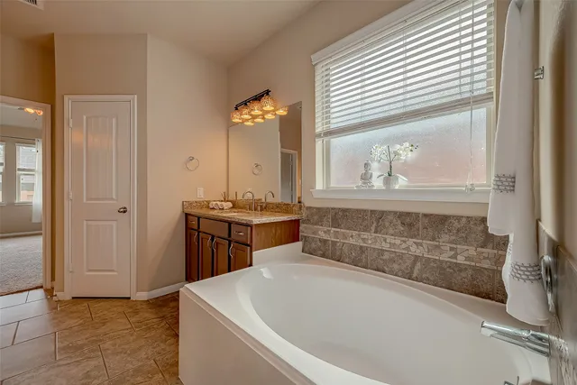 a bathroom with a tub sink and mirror