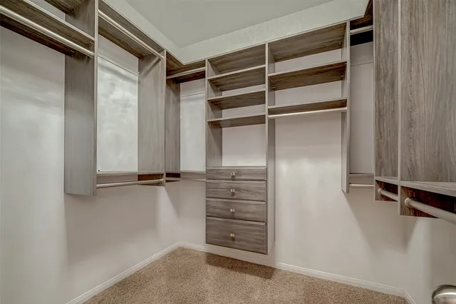 a view of walk in closet with empty racks